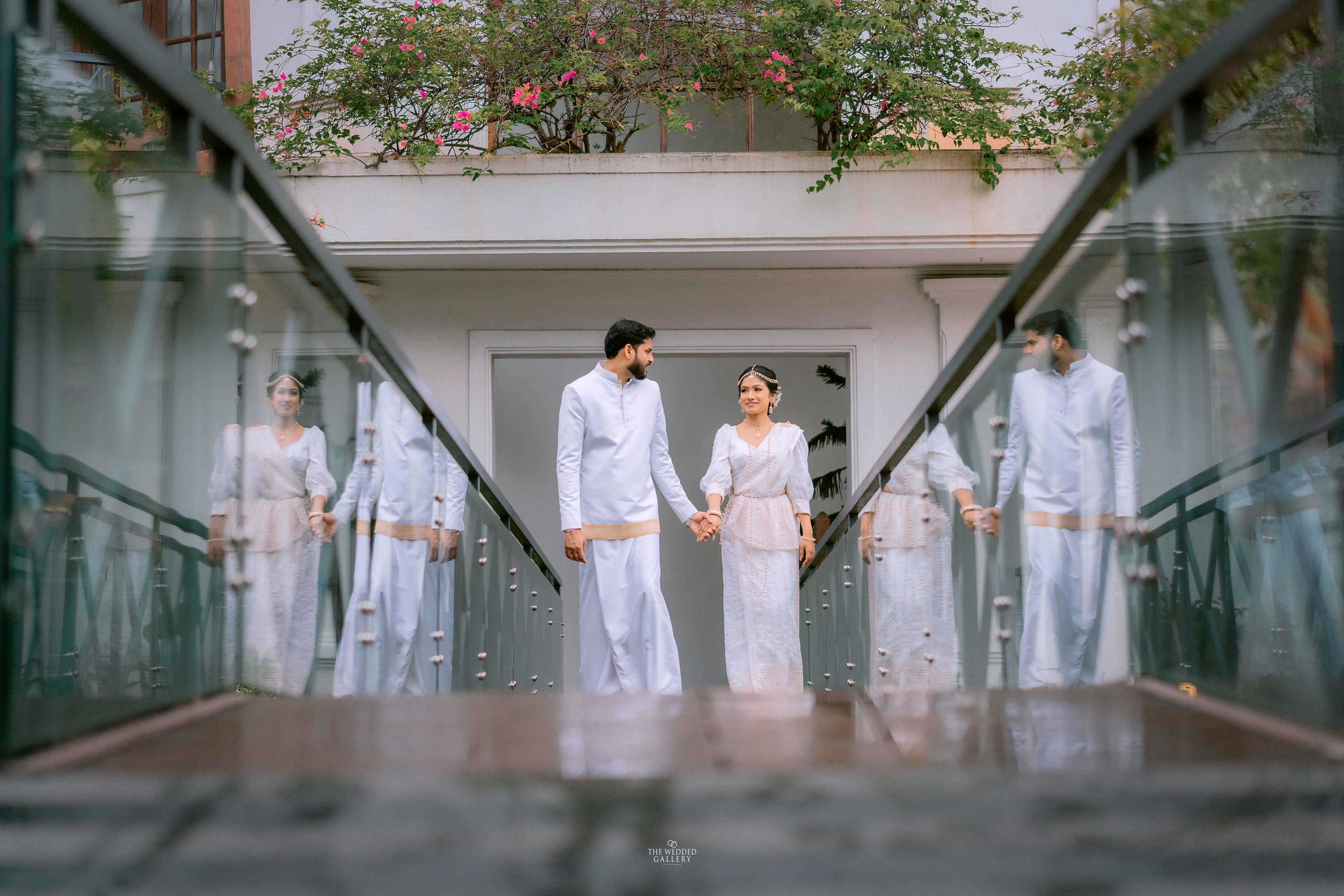 Couple on a glass walkway with their reflections repeating on both sides